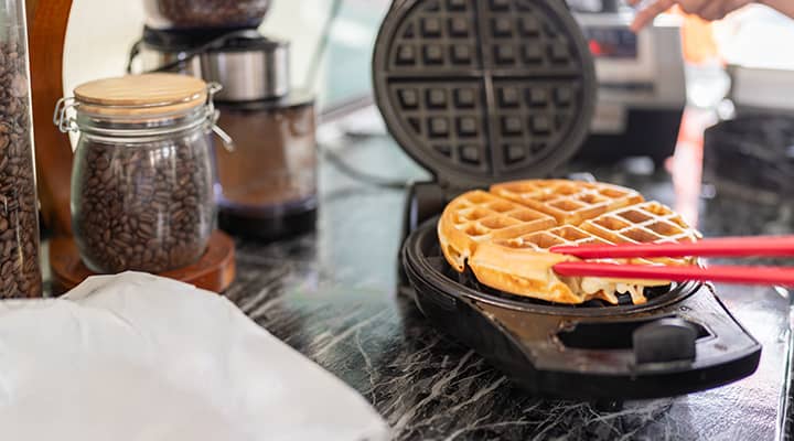 istock - continental breakfast waffles - cropped a waffle being made at a hotel breakfast bar